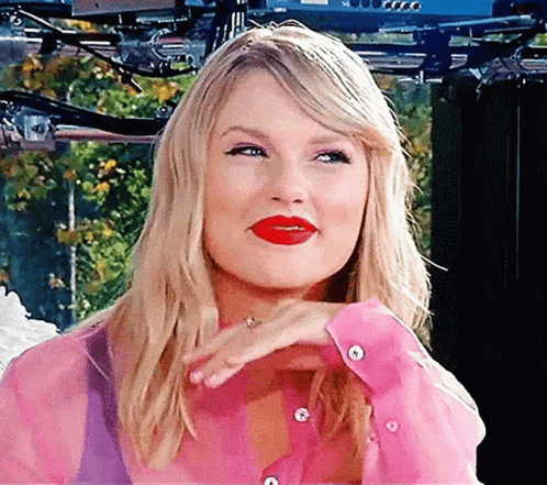 Taylor Swift deslizando su mano debajo de su cara mientras sonrie de felicidad porque ahora hay una materia con su nombre en Harvard.- Blog Hola Telcel