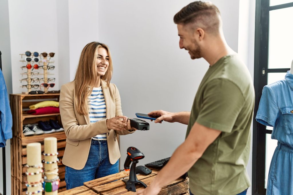Persona usando medios de pago digitales en un comercio